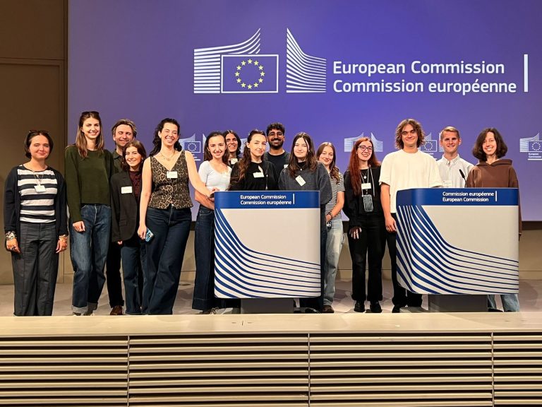 Group of people standing in front of European Commission sign